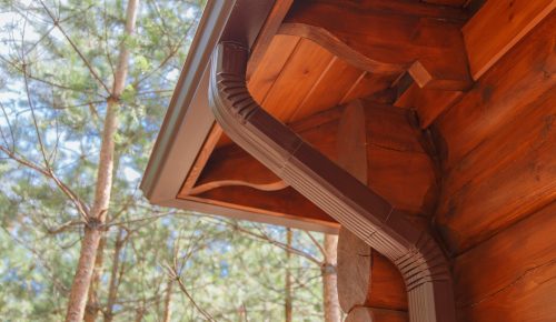 Roof gutter system on log house in forest Roof gutter system on log house in forest